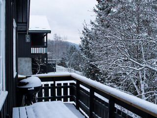 Snow-covered trees, porch and grill in the mountains of Norway
