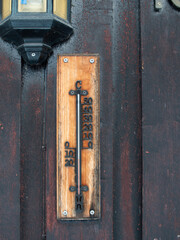 Old worn thermometer placed outside in the cold on old painted wodden facade