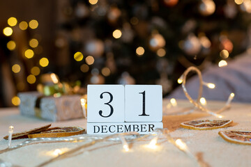 calendar with the date December 31 on the background of candles and Christmas decor in gold color