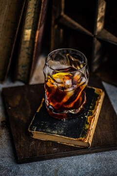 Close-up of a vodka martini cocktail with old books on a table