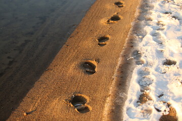 Foot steps on beach at winter time