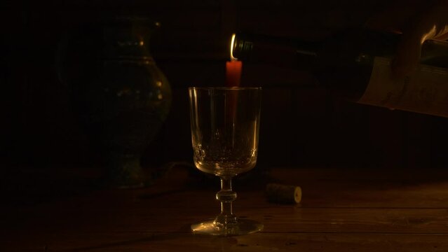 Vin rouge servi dans un verre de cristal avec bouteille de vin &agrave; la lumi&egrave;re d'une bougie
