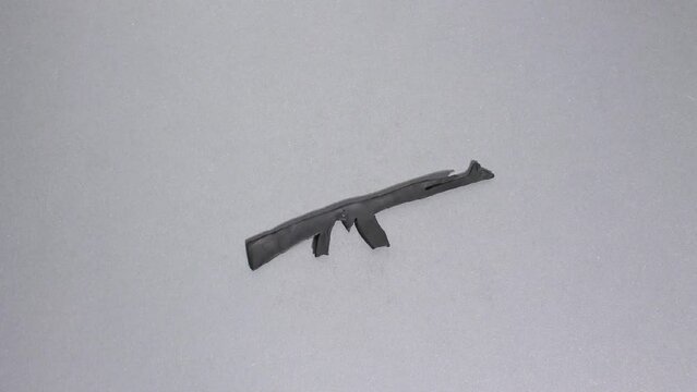 Plasticine claymotion stop motion animation, Ukrainian bandura turns into a black machine gun on a gray background
