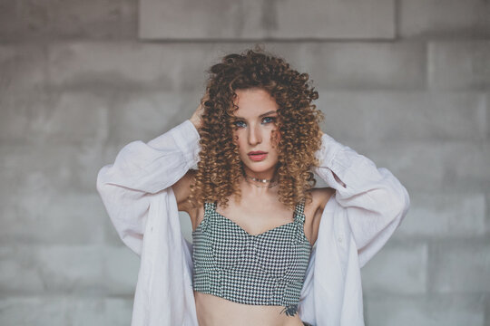 Beautiful happy woman with curly hair looking to the camera