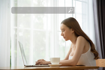 Asian young woman using laptop searching data with blank search bar. Internet data search...