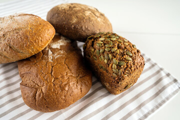 Delicious fresh bread lies on the breakfast table on a white table.