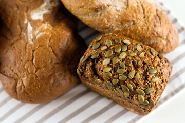 Delicious fresh bread lies on the breakfast table on a white table.