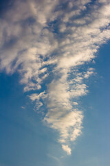 Clouds in the shape of a triangle against a blue sky, vertical view