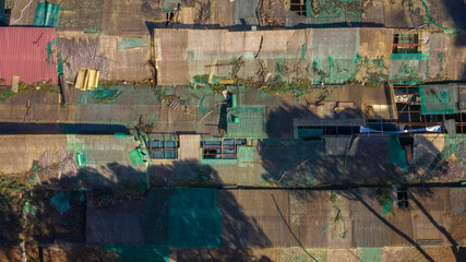 Perpendicular aerial view of the tin roofs of a poor neighborhood on the outskirts of a large city.