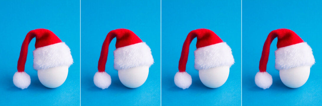 Christmas collage. White chicken egg with Santa Claus hat on the blue background. Copy space.