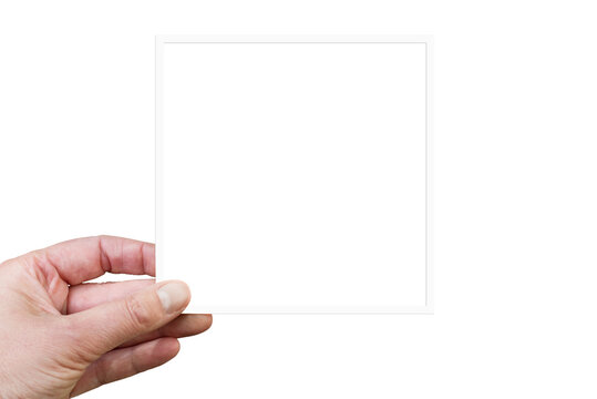 Hand holding a blank square white frame or instant photogrpahy isolated on transparent background