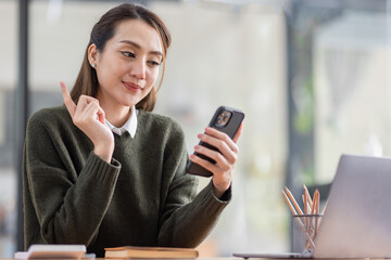 Cheerful Asian business woman work in workspace office. do math finance on wooden desk in office, tax, accounting, financial concept.