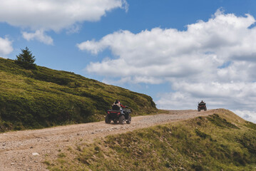 People Driving Quad Bikes on Mountain Hill