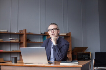 Concentrated businessman planning workday. Focused senior man portrait