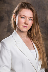 Portrait of a young red-haired woman in a dark studio