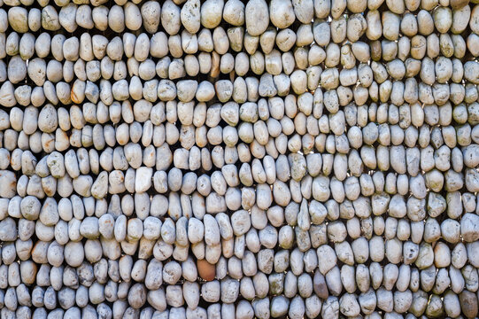wall of pebbles piled up forms abstract pattern