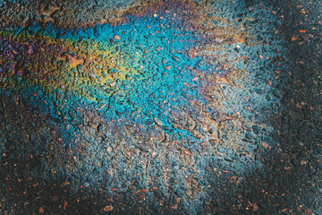 An oily iridescent stain of gasoline or oil spilled on the road.