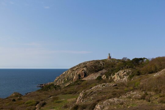 Aerial view of a cliff overlooking the ocean with the Kullen lighthouse, Sweden in the distance