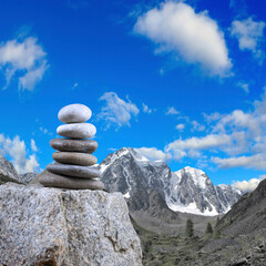 Pyramids of stones against the backdrop of mountains are a symbol of calm and balance. Zen meditation concept.