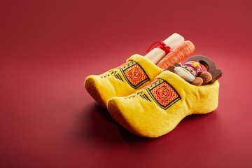Saint Nicholas - Sinterklaas day with shoe, carrot and traditional sweets on red background