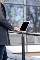 Close up of business man hands using modern technology, mobile phone and laptop outdoors