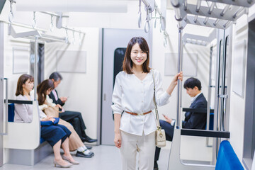 Fototapeta na wymiar 笑顔で電車に乗る若い女性