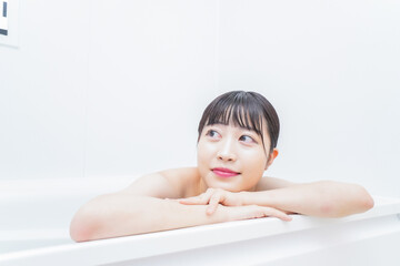 お風呂でお湯に浸かる若い女性