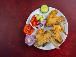 chicken wings and side salad healthy snack white plate on a burgandy background 5
