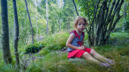 Bambina nel bosco in uno sfondo magico che evoca folletti e gnomi