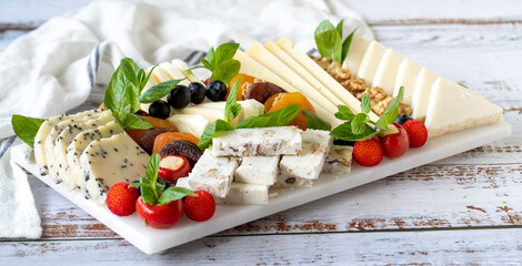 Mixed cheese plate on wood floor. Delicious assortment of cheeses. Camembert, Brie, Parmesan blue cheese, goat