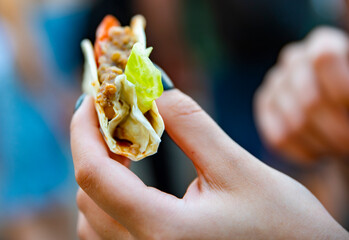 woman hand holding mini taco traditional in mexican food. street food