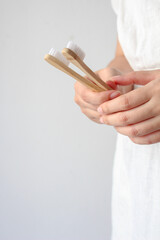 Woman hand holding bamboo toothbrushes, sustainable lifestyle concept. zero waste home,  eco-friendly personal hygiene products.