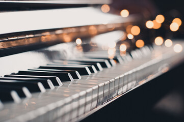 Piano keys over glow Christmas lights close up. Romantic lifestyle. Valentines Day. © morrowlight