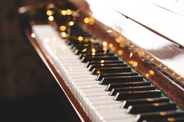 Piano keys over glow Christmas lights close up. Romantic lifestyle. Valentines Day. © morrowlight