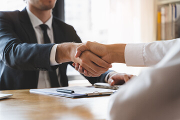 hand of client and banker shaking hands  on the meeting table after business investment budget done