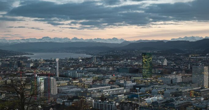 High viewpoint time-lapse footage of Zurich city Switzerland, Europe. Late evening into early night. Partially cloudy sky, late autumn, lake Zurich and Prime Tower in the background