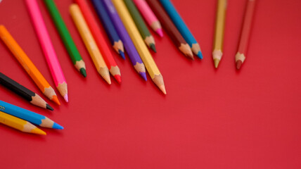 close up color pencil set, isolated on red background.