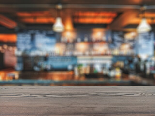 The empty table wooden board in front of the background is blurred. Brown wood perspective over the blur in the bar shop - can be used to showcase or montage your products. Mock up for product display
