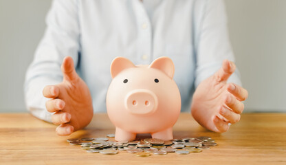 Hand holding piggy bank on wood table. Save money for wealth, financial investment business, future...
