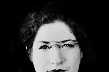 Grainy blurred multiple exposure black and white art photograph of a woman with a third eye(s). 