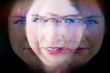Grainy blurred multiple exposure color photograph of a woman with a third eye(s). . Woman of many eyes.