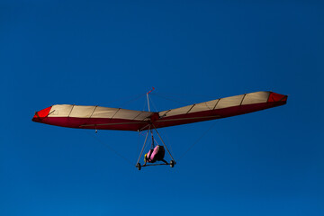 man flying his hang glider under a beautiful blue sky