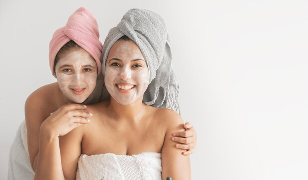 Happy mother and daughter with facial masks hugging - Powered by Adobe