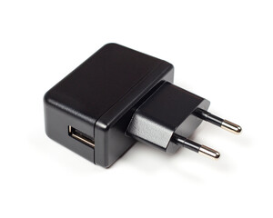 Black charger adapter on a white background. Charger with USB output.