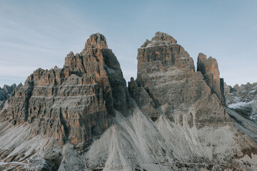 Zwei Personen in roten Jacken vor den drei Zinnen in den Dolomiten. Wandern Tre Cime. Letzte Sonnenstrahlen in den Bergen 1