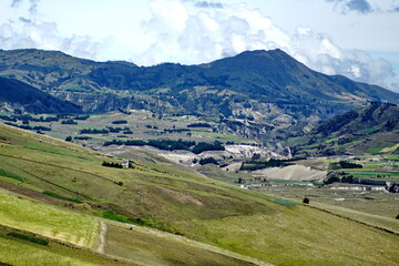 Fototapeta na wymiar Farm fields carved out on the lower slopes of a mountain near Latacunga, Ecuador
