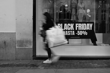 Madrid, Spain- November 25, 2022: Black Friday begins in the streets of Madrid. People with bags on the streets during Black Friday. Madrid's Gran Via fills up with people during Black Friday