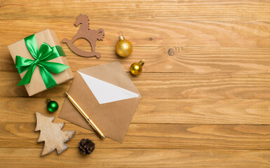 Craft envelope with christmas decoration on wooden background, top view
