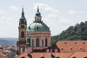Obraz premium Old Saint Nicholas church with clock tower in Prague, Czech Republic. Cityscape view of Prague old town, high view point