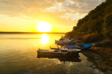 Lake view with boats at sunrise.
